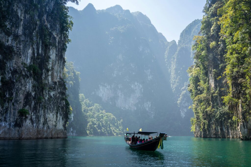 Long tail boat between cliffs