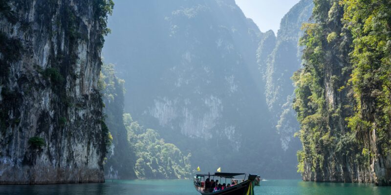 Long tail boat between cliffs