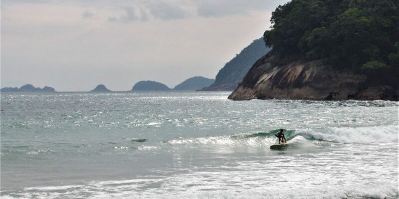 Surfer riding a wave on a tropical beach in Thailand